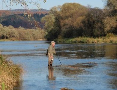 Fly fisherman Lawrence Greasley contemplates the island water at Zaluz on the San River in Poland.